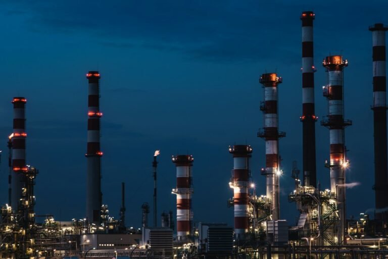 Refinery process units, towers and pipework at dusk